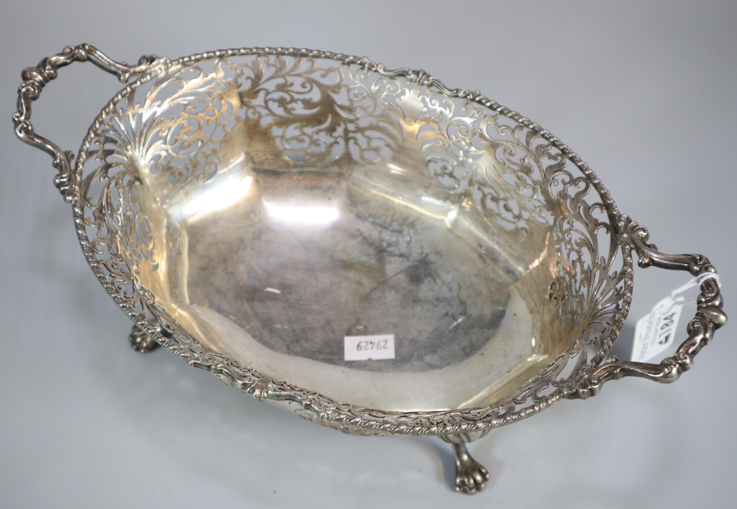 George V silver ornate and pierced two handled centre bowl, raised and standing on four shell and