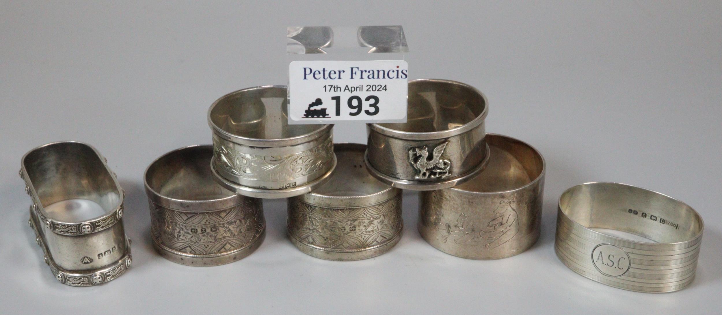 A bag of various silver napkin rings, together with 1 silver plated, decorated with bears. The