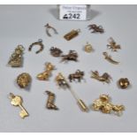 Collection of 9ct gold and other charms to include: horse shoe, race horses, wishbone, dogs, gold
