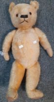 Early 20th century mohair teddy bear with glass eyes, stitched nose and moveable limbs, bearing