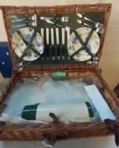 Wicker picnic hamper with accessories together with a modern folding and travelling picnic table. (