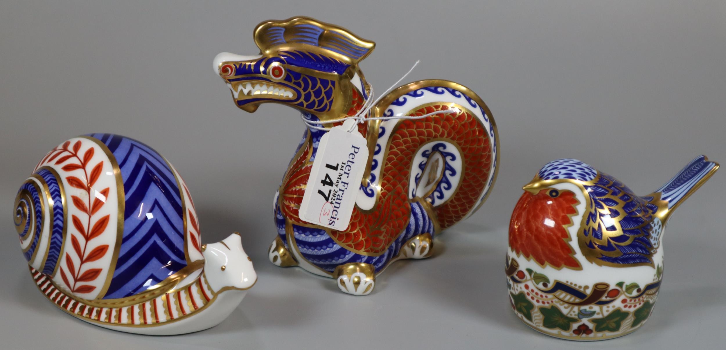 Three Royal Crown Derby English bone china paperweights; 'Robin Nesting' with silver stopper and two