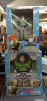 Two Buzz Lightyear Toy Story figures in original boxes; a Buzz Lightyear electric talking bank and