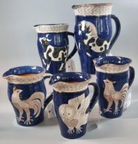 Sally Seymour (Penfro), a collection of five Welsh studio pottery jugs depicting: roosters, cow,