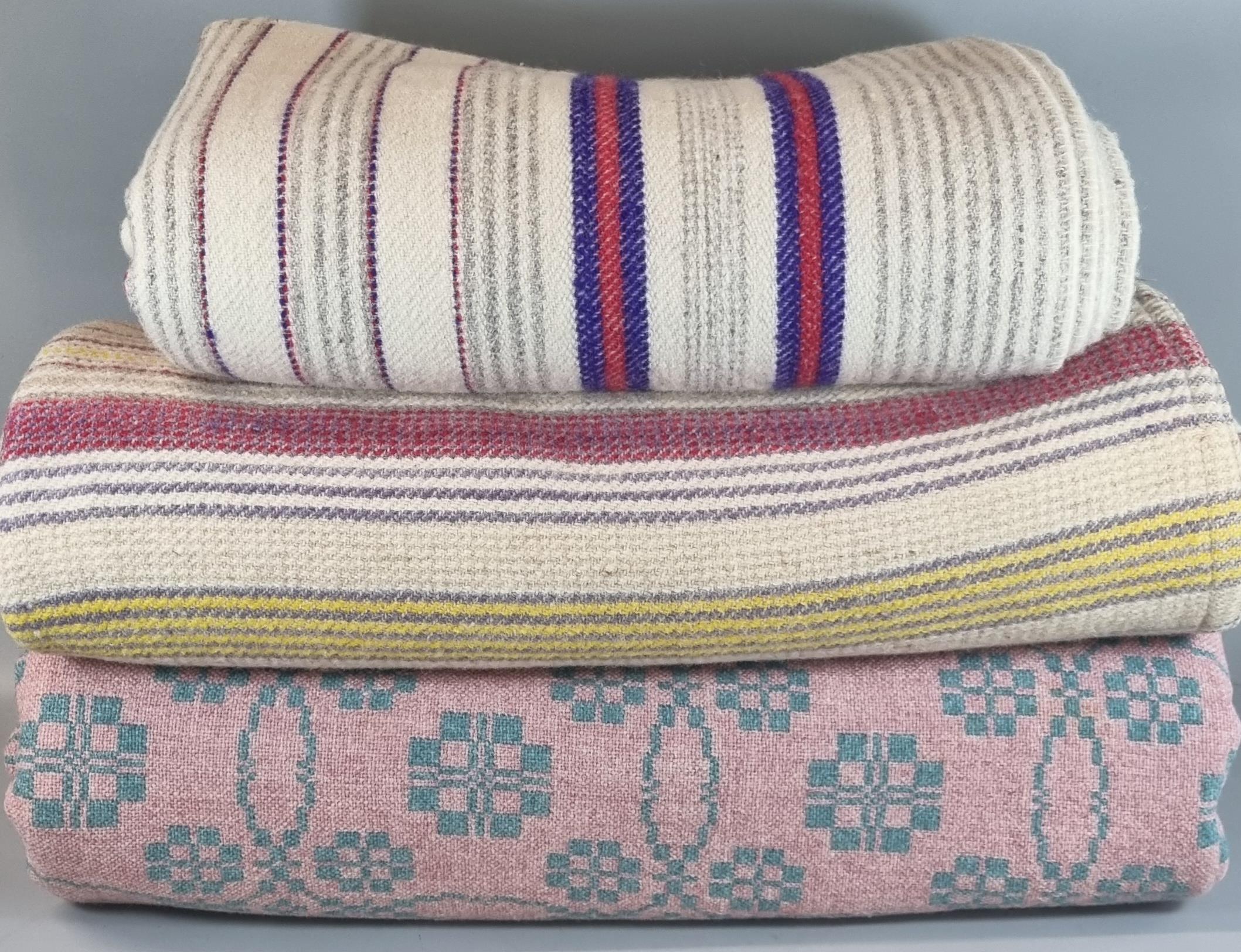 Three vintage woollen blankets or carthen to include: two striped narrow loom and a pink and cream