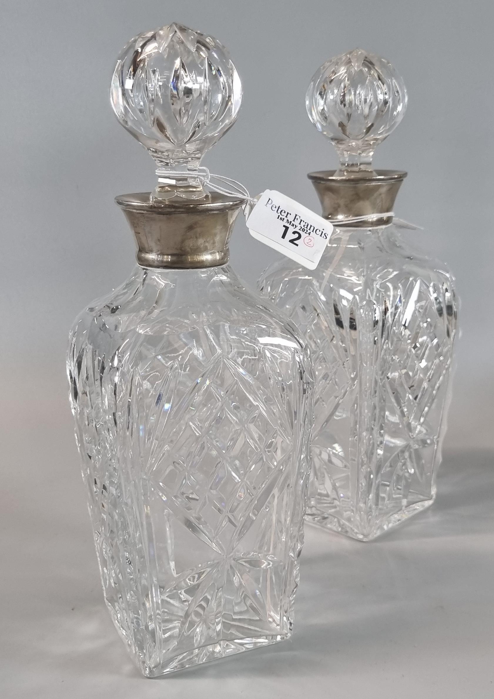 Pair of cut glass square section decanters and stoppers with silver collars. (2) (B.P. 21% + VAT)