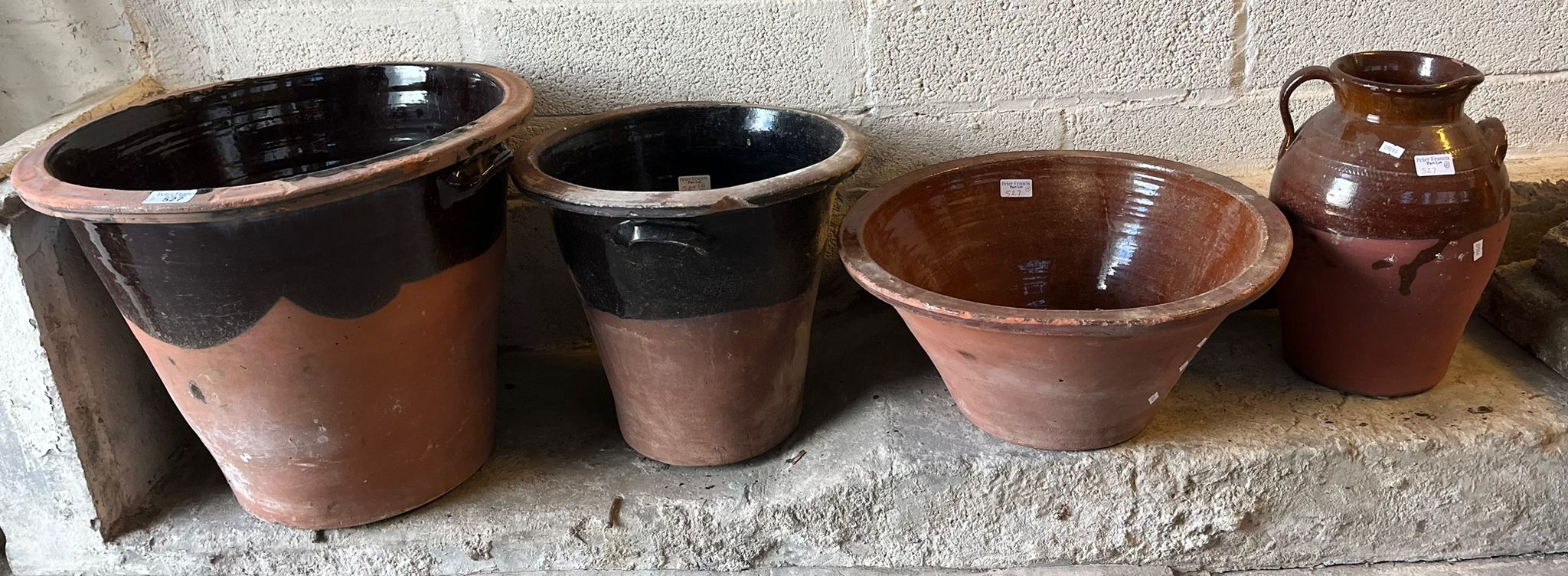 Three terracotta dairy pans/pots together with a terracotta single handled baluster jug. (4) (B.P.