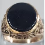 Yellow metal and black hardstone signet ring with lion mask mounts to each shoulder. 7.5g approx.