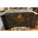 20th century heavily carved camphor wood chest, overall depicting figures, pagodas in a