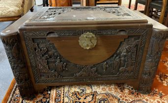 20th century heavily carved camphor wood chest, overall depicting figures, pagodas in a