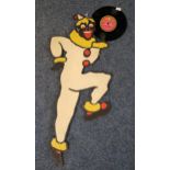 Printed/painted carboard clown figure holding a 1974 vinyl record 'Whistle while you work' by The