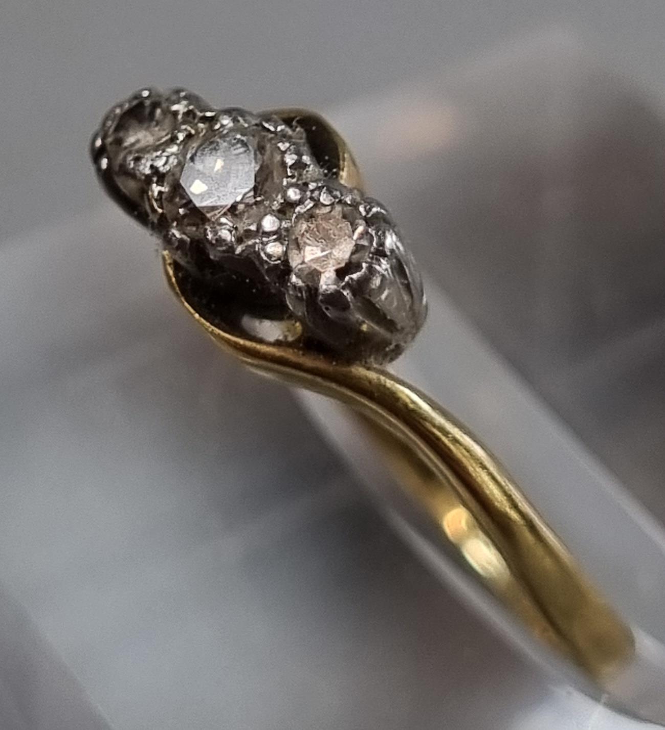 18ct gold and platinum twist shank three stone diamond ring. 1.8g approx. Size I. (B.P. 21% + VAT)