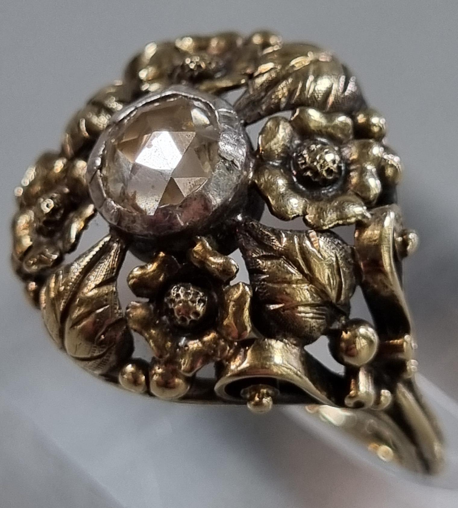 14ct gold Arts and Crafts style ring set with a rose cut diamond in ornate floral setting. 4.9g