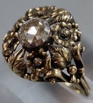 14ct gold Arts and Crafts style ring set with a rose cut diamond in ornate floral setting. 4.9g