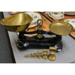 Set of black enamel kitchen scales with copper pans and graduated set of brass bell shaped