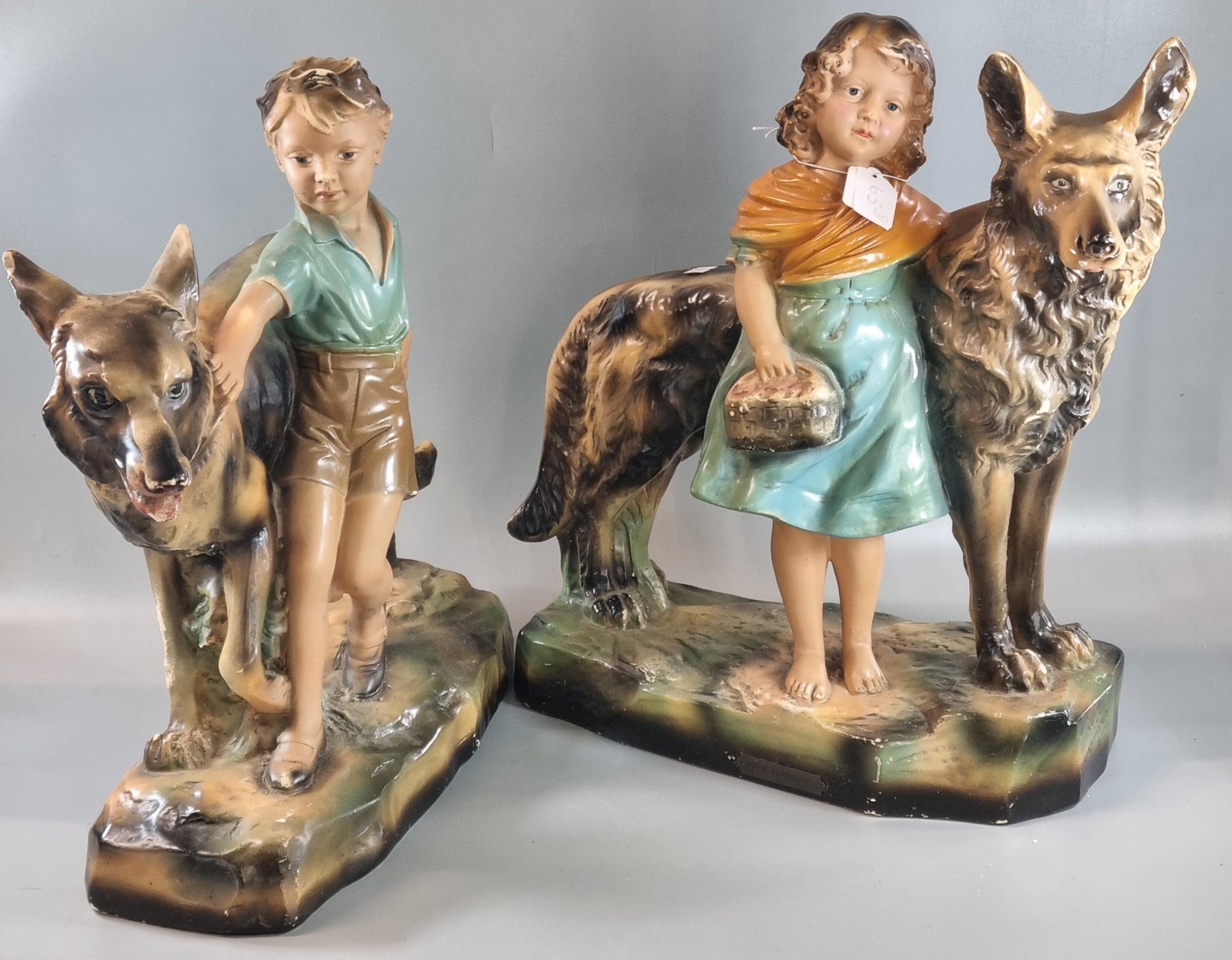 Pair of Art Deco design chalk/plaster figure groups of dogs with a young girl and boy on