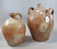 Rustic stoneware two handled flagon together with another stoneware single handled flagon. The