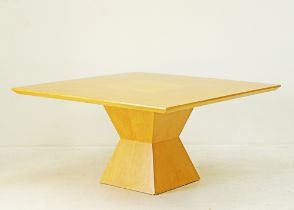 A square dining table veneered in maple