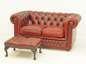 A chesterfield sofa and ottoman in leather