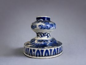 AN UNUSUAL ORIENTAL PORCELAIN CANDLESTICK. Painted blue & white foliate pattern. Height - 12cm AF