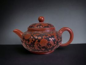 A CHINESE YIXING CLAY SMALL TEAPOT. Intricately carved with Chrysanthemum & stylised leaves.