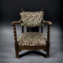 A VICTORIAN UPHOLSTERED OAK SLIPPER CHAIR. With carved Barley twist arms and foliate design