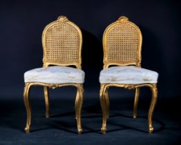 A PAIR OF FRENCH GILT CANE BERGERE CHAIRS. Shell stylised finial to backrests, with upholstered