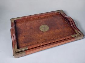 A PAIR OF CHINESE WOODEN SERVING TRAYS. Early 20th century. Graduating sizes, with handles and metal