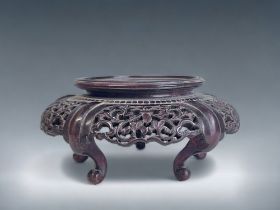 A CHINESE CARVED WOOD STAND. Raised on four curved feet. With stylised foliate design.