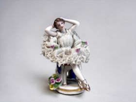 A Dresden Porcelain Lace Figurine. Hand painted Ballerina seated on a chair. Marked to base.