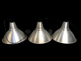 A set of three retro brushed aluminium industrial lamp shades/lights.