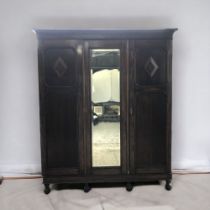 A Carved Oak Triple Wardrobe with drawers and shoe rack.