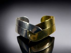 A VINTAGE 18CT GOLD & SILVER BANGLE. Conjoined in the centre. Stamped 750 to one side and 925 to the