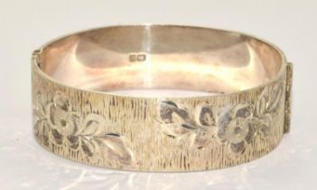 Solid silver bangle with half flower decoration and centre hinge