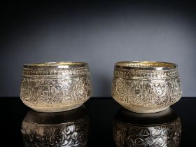 A PAIR OF BURMESE SILVER THABEIK BOWL. Repousse decorated with fish and crabs amongst stylised