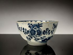 A blue & white hand painted porcelain tea bowl. Lowestoft, C1770. Painted flowers growing out of a