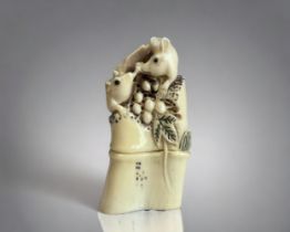 A Japanese carved Walrus tusk Okimono. Depicting mice eating berries. Signed to base. 6.5cm tall