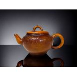 A CHINESE CARVED AMBER TEAPOT. Qing dynasty. Carved Tokens with script to body and lid. Impressed