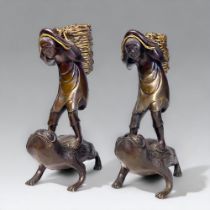 A PAIR OF JAPANESE BRONZE OKIMONO. Meiji period. Depicting men stood on the backs of toads, carrying