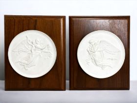 A pair of Royal Copenhagen bisque porcelain roundel plaques. Mounted on wood. Depicting 'Eneret, Day