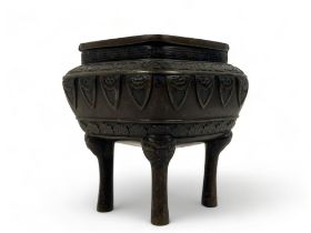 A Chinese bronze censer. Qing dynasty. raised on fourTaotie mask feet, with stylised motifs below