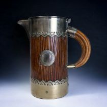 A CHRISTOPHER DRESSER FOR HUKIN & HEATH WATER JUG. Textured wodd & metal design, with tu8sk shape