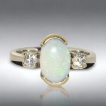 A ladies 18ct white gold Fiery Opal and Diamond ring. Central oval cut opal, bordered by two round