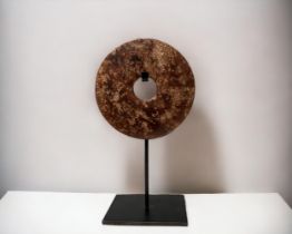 A Chinese carved Serpentine Bi-disc. On metal stand. Diameter - 12.5cm Height on stand - 22cm