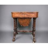 A VICTORIAN BURR WALNUT WORK TABLE. Carved legs raised on original casters. Joined by turned wood
