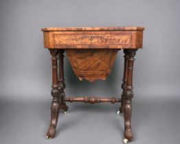 A VICTORIAN BURR WALNUT WORK TABLE. Carved legs raised on original casters. Joined by turned wood