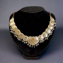 A PERSIAN? WHITE & GILT METAL ENAMELLED CHOKER NECKLACE. Stylised foliate design, with drop pearls &