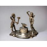 An Edwardian silver miniature figure group. By Berthold Muller. Depicting winged cherubs forging.
