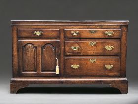 AN early 18th century Oak side cupboard. Plank top above four drawers and arched door. On bracket