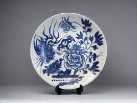 A CHINESE PORCELAIN BLUE & WHITE DISH. Qing dynasty. Painted with a Phoenix and large blossoming